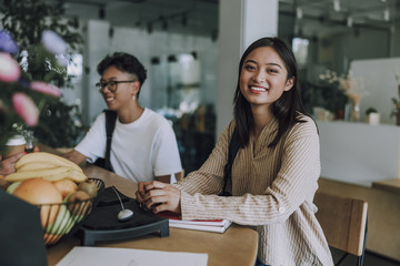Fototapeta premium Pretty smiling female student with notebook in cafe