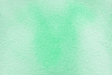 Many multi-colored spangles are scattered on a mint background. Neo color. View from above. Place for text.