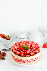 Strawberry cake Fraisier on the white plate and cups
