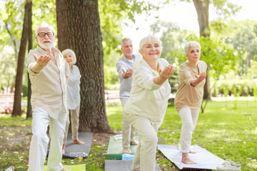 Smiling old people practicing qigong in the park