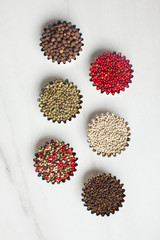 Bowl of black pepper on old wooden table