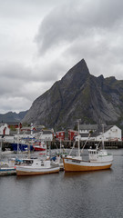 Hamnoy in den Lofoten mit Schiffen im Hafen und Berge 