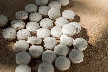 Fototapeta na wymiar closeup of medical pills on wooden board