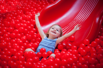 Fototapeta na wymiar laughing little girl riding a slide