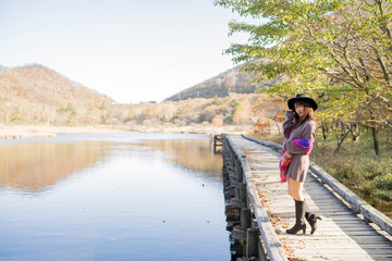 Naklejka premium 紅葉と湖と女性
