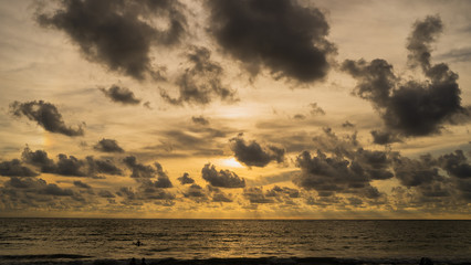 Fototapeta premium A of the large dark tone sunset as the massive sun sets into the horizon above the ocean, Sunset sky clouds. Sunset sky background. Sunset sky orange blue.at Phuket Thailand.;
