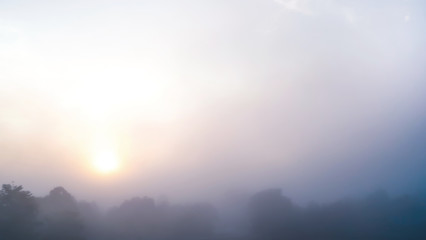 Colored sunrise in forested mountain slope with fog ,View from the mountain in the morning, Surat Thani, Thailand.