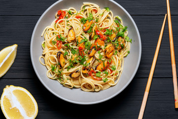 Pasta Spaghetti seafood with mussels Marinara, Typical dish of Italian pasta. top view. on a black background with a place for text, copy space