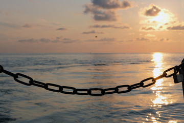 Silhouette of a chain and lock with sunset background