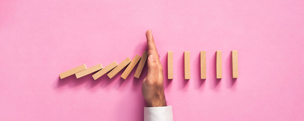 Chain Reaction In Business Concept, Businessman Intervening Chain Dominoes Toppling