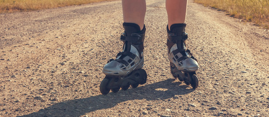 teenage girl rollerblading on the street on the road in the countryside on a summer evening at...