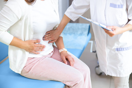 Doctor Examining Woman With Stomachache Stock Photo