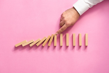 Chain Reaction In Business Concept, Businessman Intervening Chain Dominoes Toppling