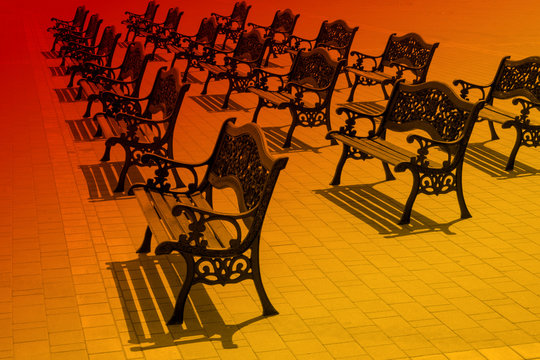 Theater benches in red-orange surreal light.  Park benches for viewing performances