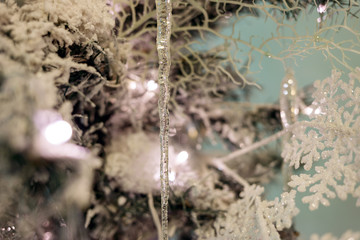 Christmas tree with white artificial snow on branches and decorations.