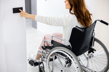 Adult woman pushing sensor button on wall