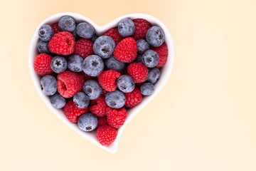 Creative layout made of Blueberry and raspberries on pastel background. Food ingredient pattern.