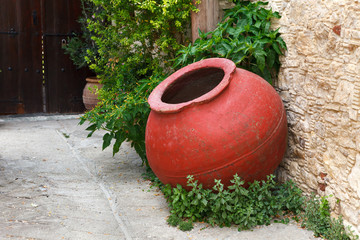 Large, old, red amphora on the street of the wine village