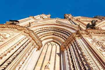 Orvieto, Italy. Perspective view of the Cathedral of "Santa Maria Assunta", a masterpiece of Gothic architecture. Decorated with spiers, cusps, bas-reliefs and stained glass windows.