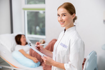 Happy doctor is holding form for patient