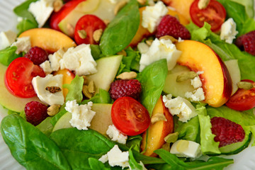 Tasty salad with peach and raspberry, closeup