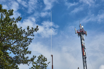 Obraz premium Lightning rod and antenna against blue sky with white clouds