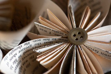 Stylish origami-type hand-made folded paper flowers constructed from buttons and pages from an old book