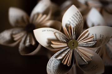 Stylish origami-type hand-made folded paper flowers constructed from buttons and pages from an old...