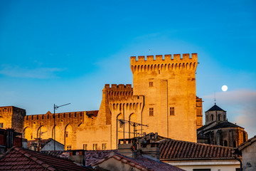 Palais des Papes Against Blue Sky and the Full Moon in Avignon, France..