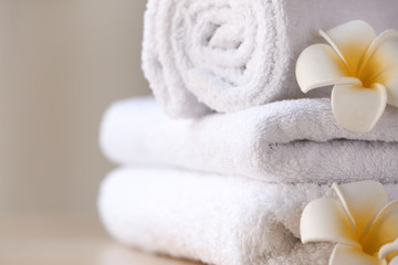 Clean towels with flowers on table, closeup