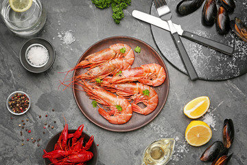Plate with tasty shrimps, crayfish and mussels on grey background