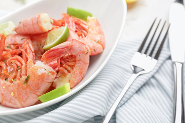 Plate with tasty shrimps on table