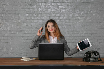 young business woman talking on the phone, holding a tablet in her hand