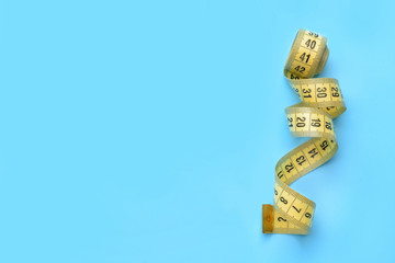 Measuring tape on color background