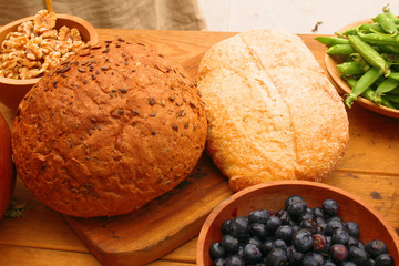 Fresh bread and fruit on wooden board