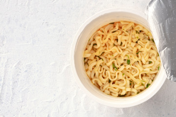Plastic cup of instant ramen noodles, shot from above with copyspace