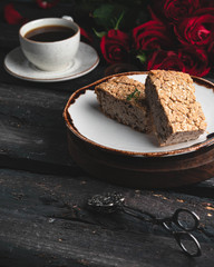 healthy bread with seeds on a white brown plate, on a dark wooden backdrop, cup of coffee and roses on background