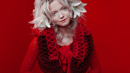 Shades of red. Portrait of a Bizarre attractive blond woman, with fashion makeup, in red fantasy...