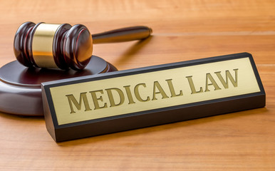 A gavel and a name plate with the engraving Medical law