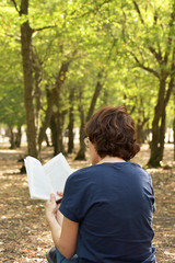 Woman reading a book in forest