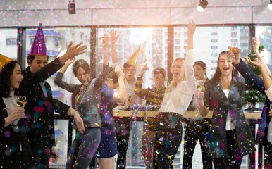 Gruppe von Büroangestellten, die gemeinsam Winterferien bei der Arbeit feiern. Geschäftsmann trinkt Champagner im Büro. Frohe Weihnachten und ein glückliches Neues Jahr. © Sun13