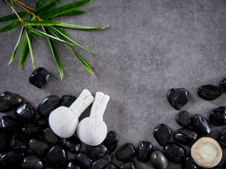 Fototapeta na wymiar Herbal compress ball place on black pebbles.