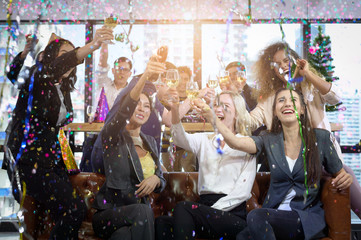 Group of office workers celebrating winter holidays together at work. Businessman drinking champagne at office. Merry Christmas and Happy New Year.