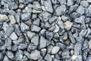 Small rocks or gravel made from  stones different shape as stone texture. Used for construction of buildings and roads and as a building material.