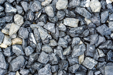 Small rocks or gravel made from  stones different shape as stone texture. Used for construction of buildings and roads and as a building material.