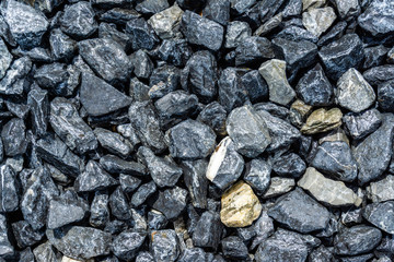 Small rocks or gravel made from  stones different shape as stone texture. Used for construction of buildings and roads and as a building material.