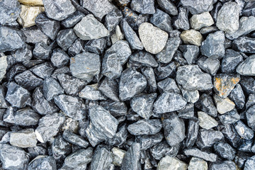 Small rocks or gravel made from  stones different shape as stone texture. Used for construction of buildings and roads and as a building material.