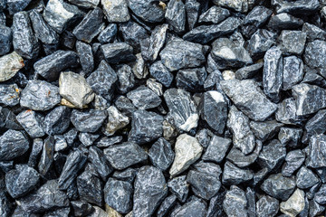 Small rocks or gravel made from  stones different shape as stone texture. Used for construction of buildings and roads and as a building material.