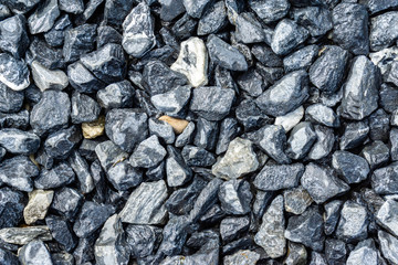 Small rocks or gravel made from  stones different shape as stone texture. Used for construction of buildings and roads and as a building material.