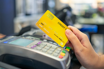 Credit card swipe machine And a young woman holding a credit card to pay for purchases using money from the card. Or installment payments